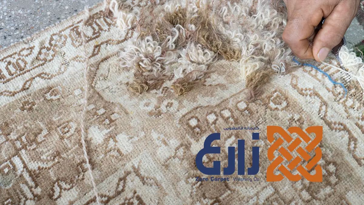 رفوگر در حال بازسازی بافت آسیبدیده فرش دستباف در کارخانه زارع